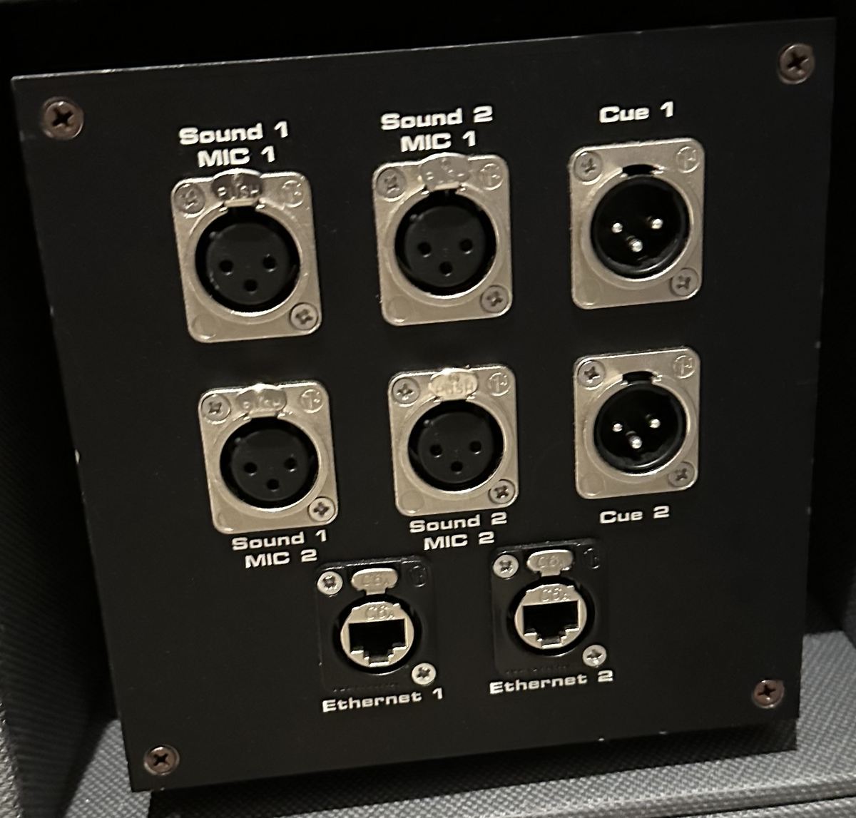 A custom engraved wall box with XLR and Ethernet connectors.