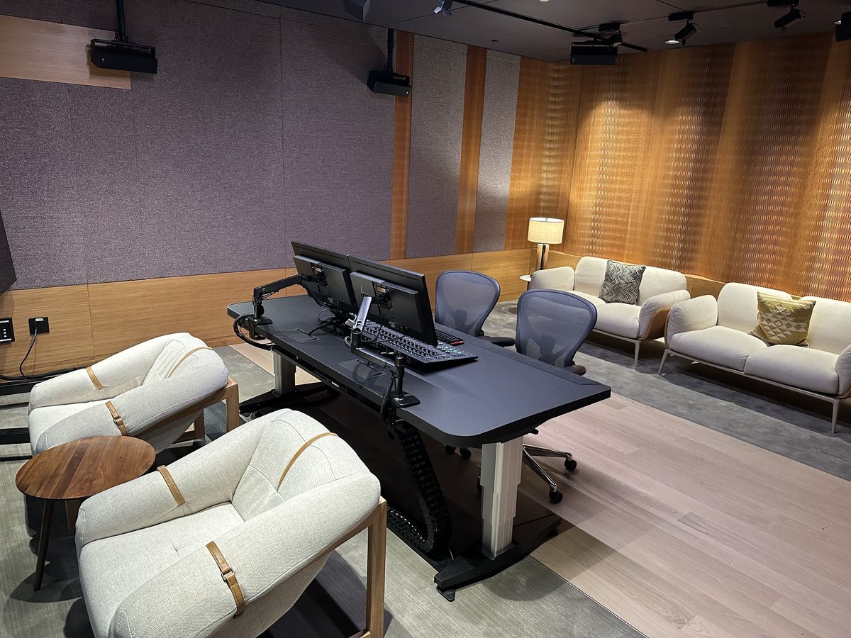 A finished control room with mixing desk, monitors and lounge seating.